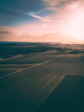 A vibrant aerial view of a sprawling farmland in Tamil Nadu during sunset.