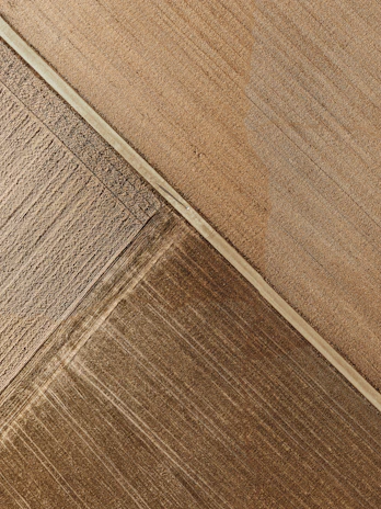 Abstract satellite-style mosaic of African agricultural fields in warm earth tones.