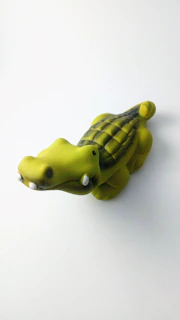 A sleepy crocodile with textured scales and a friendly smile, crafted in soft yarn.