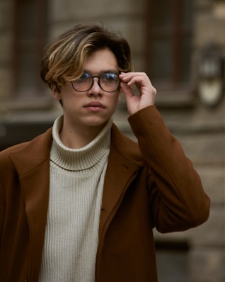 woman in brown coat wearing black framed eyeglasses