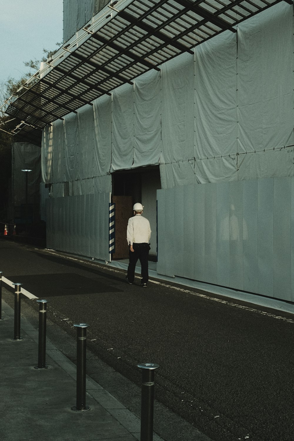 woman in white long sleeve shirt and black pants standing on gray concrete floor