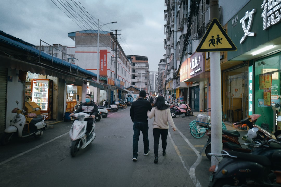 man in black jacket and black pants walking on sidewalk during daytime