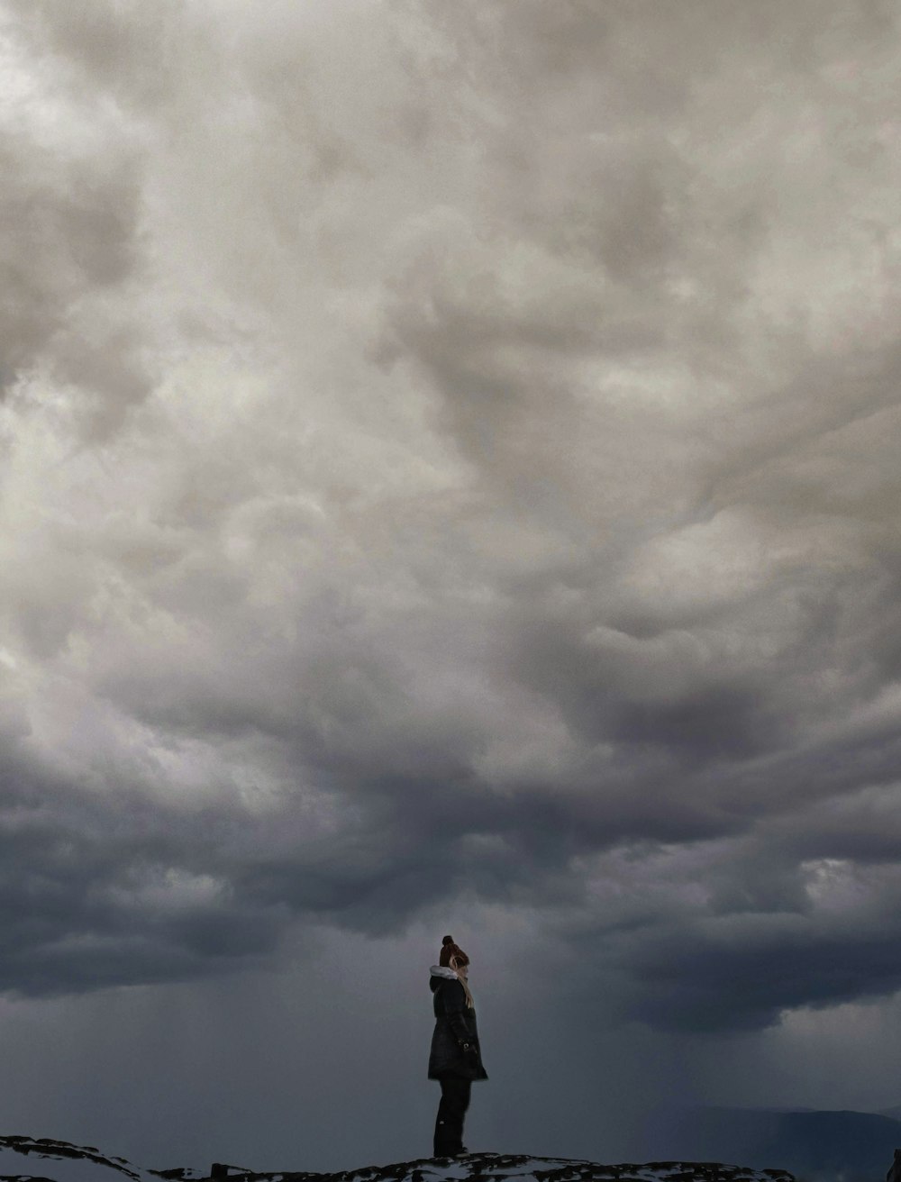 man standing under white clouds during daytime