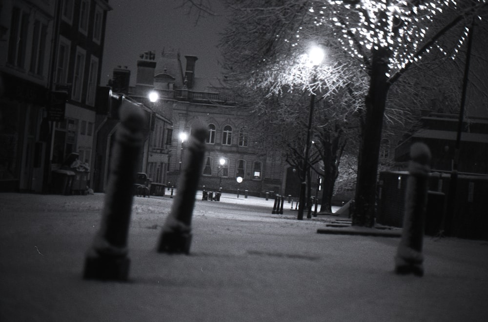 grayscale photo of street lights turned on during nighttime