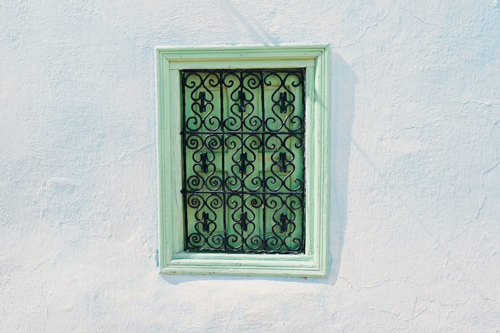 green wooden window frame on white concrete wall