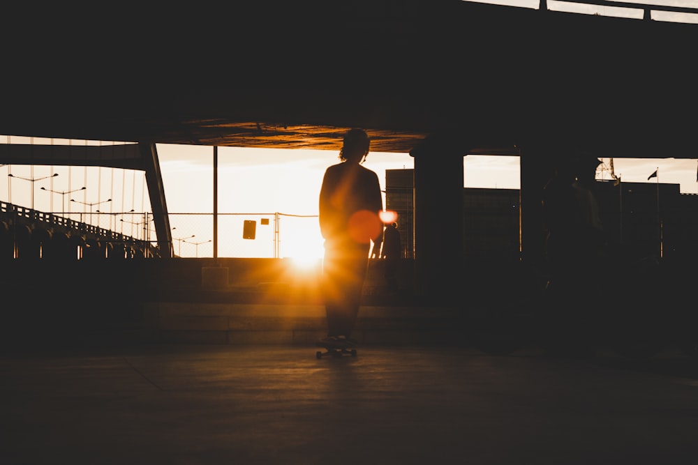 silhouette dell'uomo che cammina sulla strada durante il tramonto