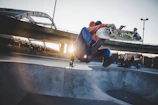 A skater performing a kickflip over a rail in downtown Salt Lake City at sunset.