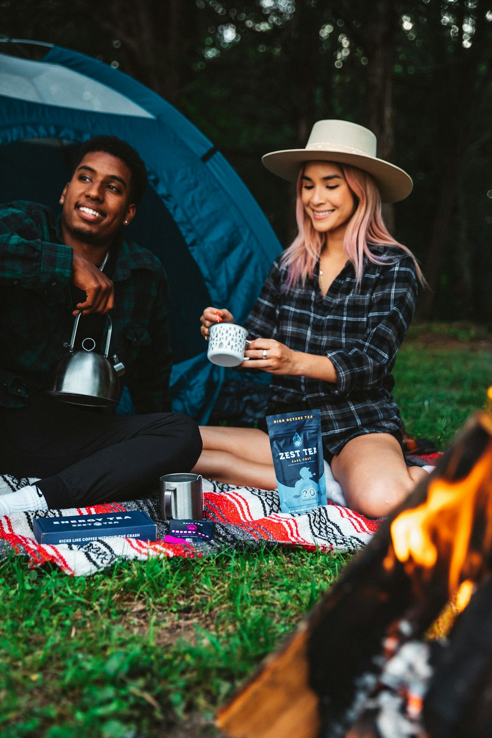 woman in black and white plaid dress shirt and blue denim shorts sitting on green grass