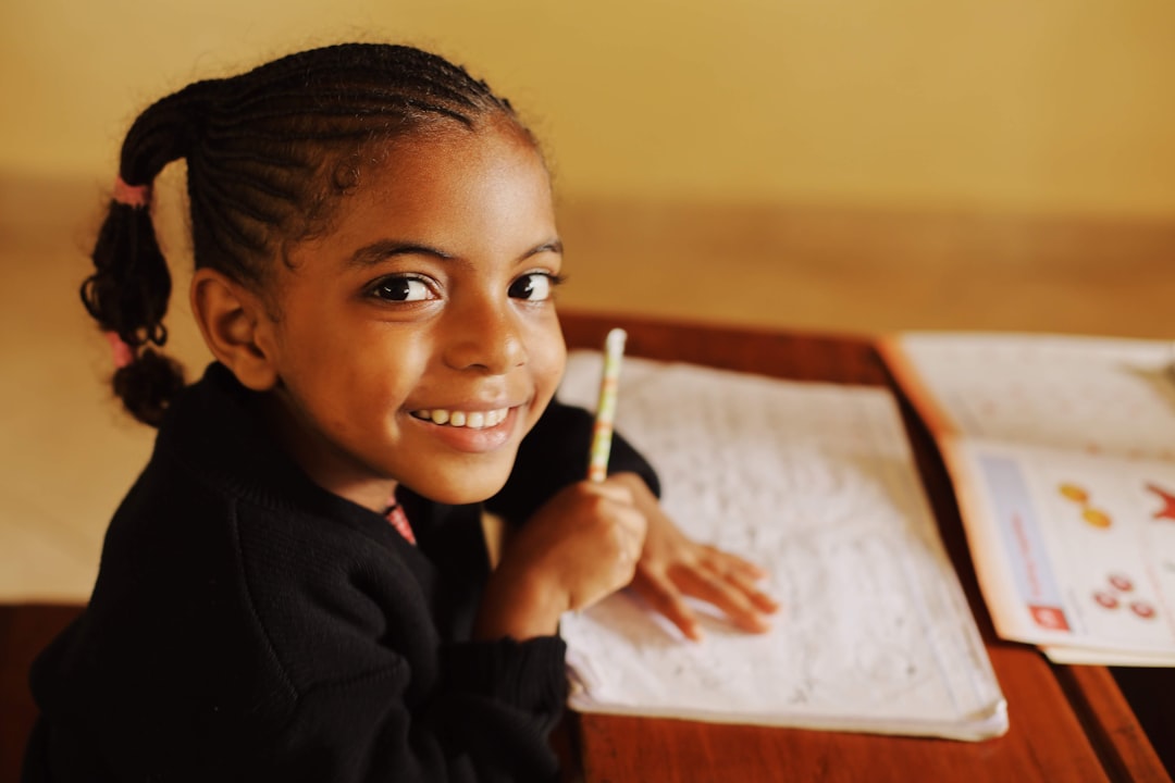 boy in black long sleeve shirt holding pen