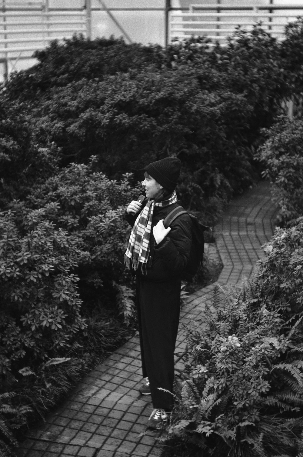 man in black suit standing on sidewalk