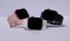 A lineup of Velix smartwatches showcasing different strap colors and materials on a wooden table.