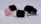 Three smartwatches are displayed on a light background. They feature different colored bands: pink, white, and black. The watches have large, rectangular touchscreens, and they are positioned to show off their sleek and modern design.
