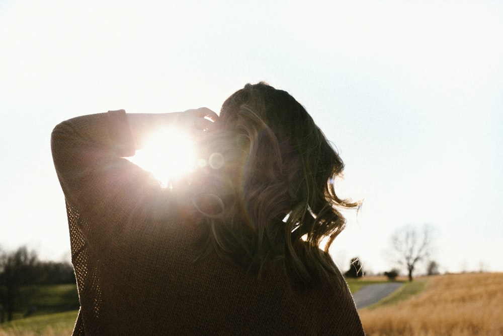 woman in black shirt standing on green grass field during daytime