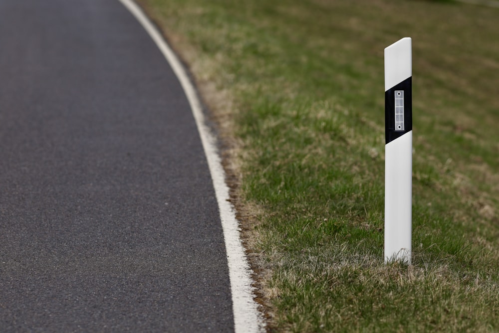 white and black road sign on green grass field