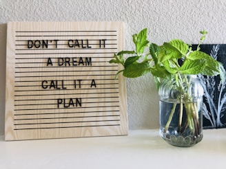 brown wooden quote board on white wall