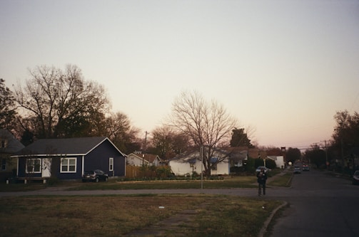 Mobile patrol vehicle driving through a suburban neighborhood at dusk.