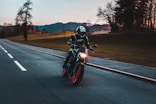 man in black helmet riding motorcycle on road during daytime