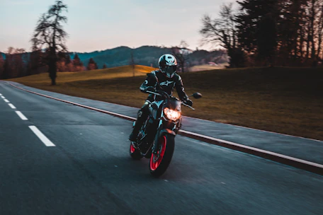 man in black helmet riding motorcycle on road during daytime