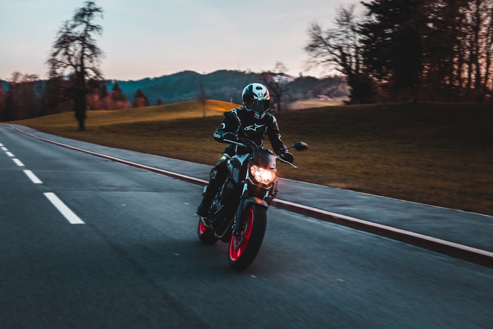 man in black helmet riding motorcycle on road during daytime