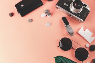 black sunglasses beside black smartphone and green and black sunglasses
