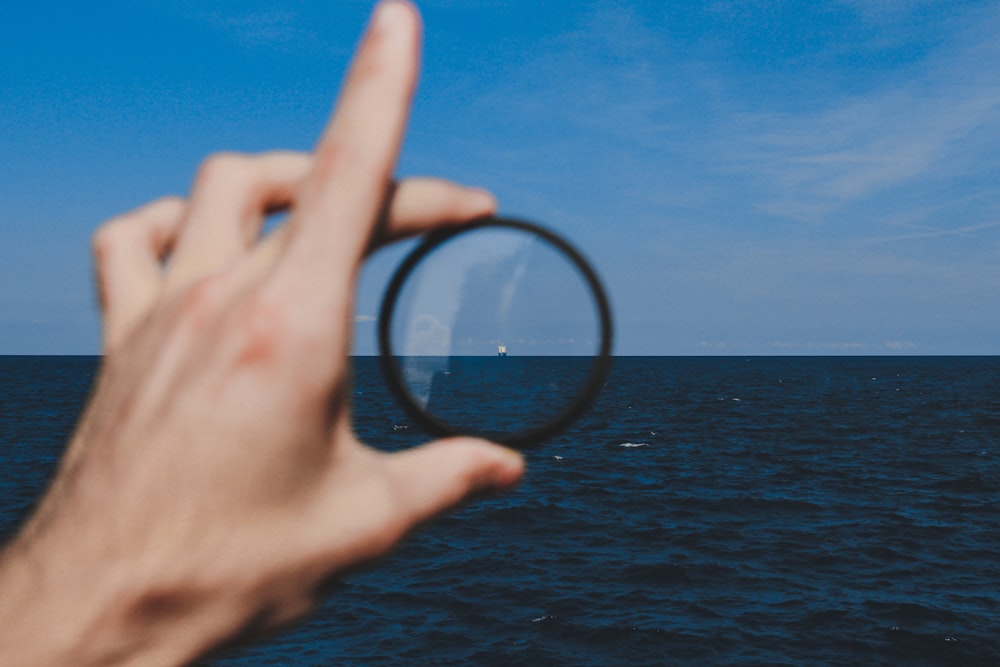 person holding magnifying glass during daytime