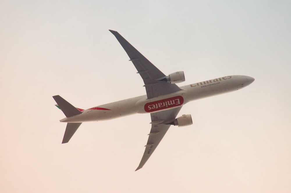 white and red airplane in mid air