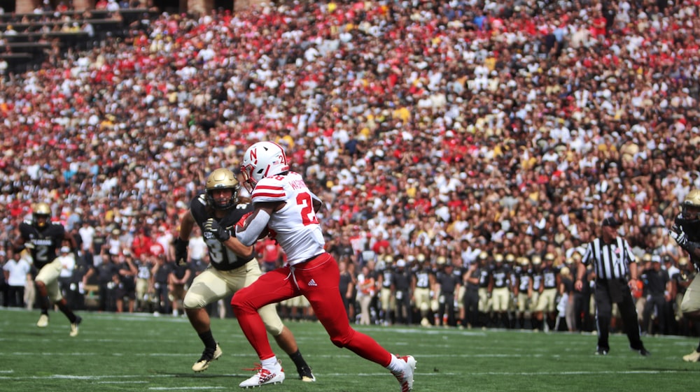 football player in red jersey shirt and black pants