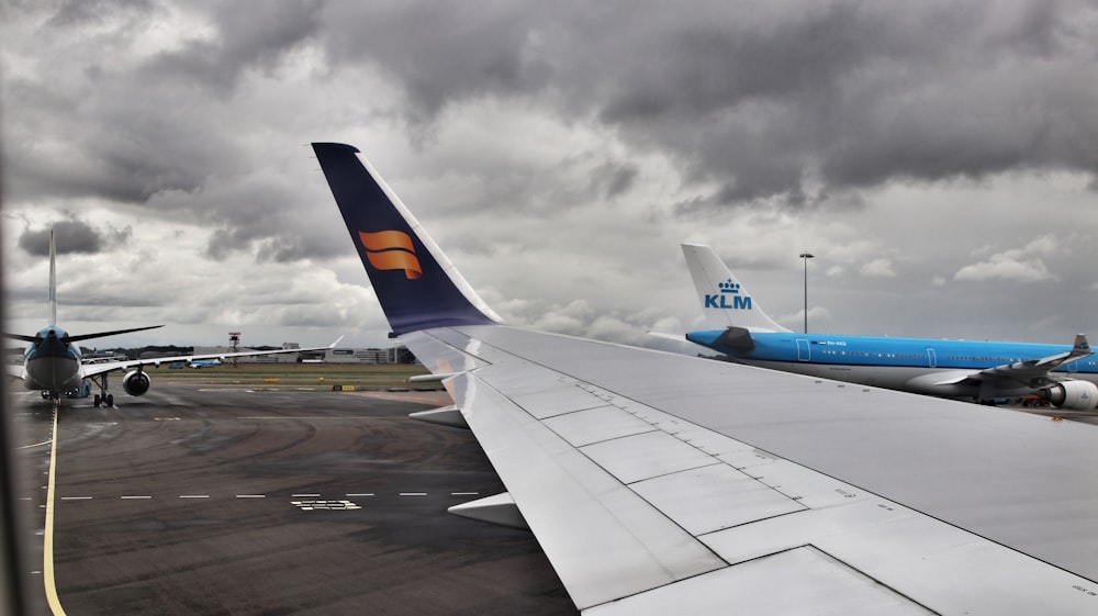 white and blue airplane under cloudy sky during daytime