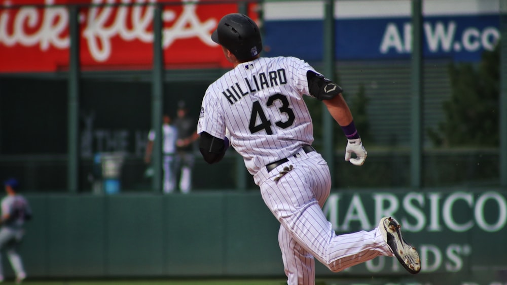 man in white and black baseball jersey shirt and white pants