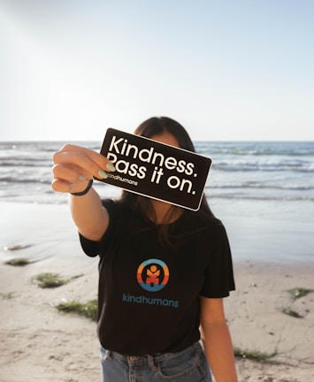 a woman holding up a sign on the beach