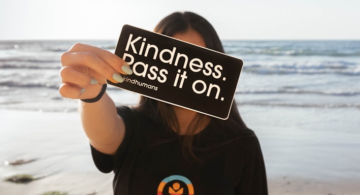 a woman holding up a sign on the beach