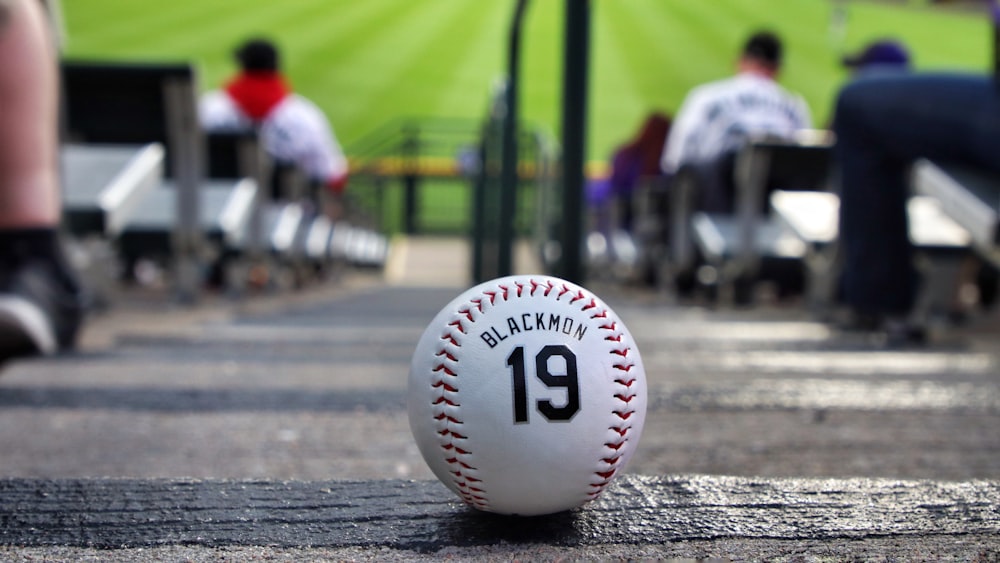 weißer und roter Baseball tagsüber auf dem Feld