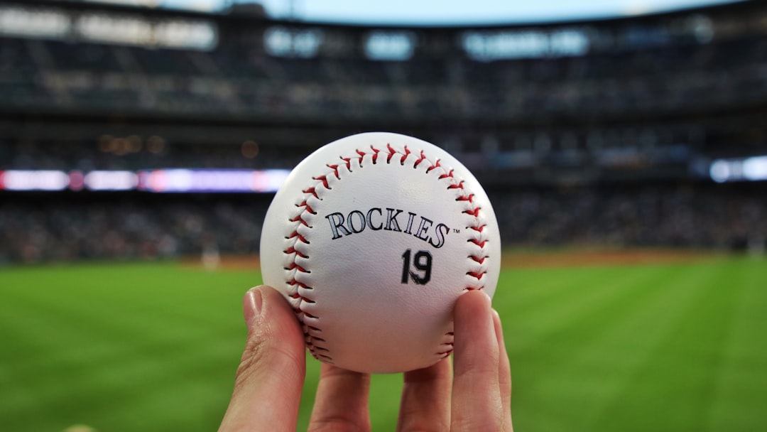 white and red baseball on persons hand