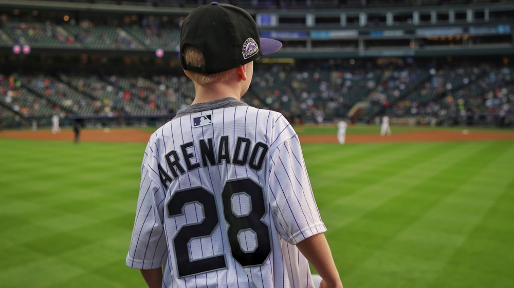 man in white and black jersey shirt wearing black cap