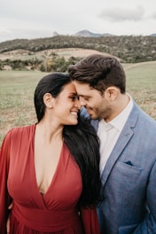 man in gray suit kissing woman in red dress