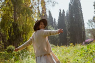 A smiling person standing in a sunlit meadow, arms wide open embracing joy.