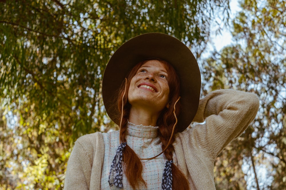 woman in beige cardigan and brown hat