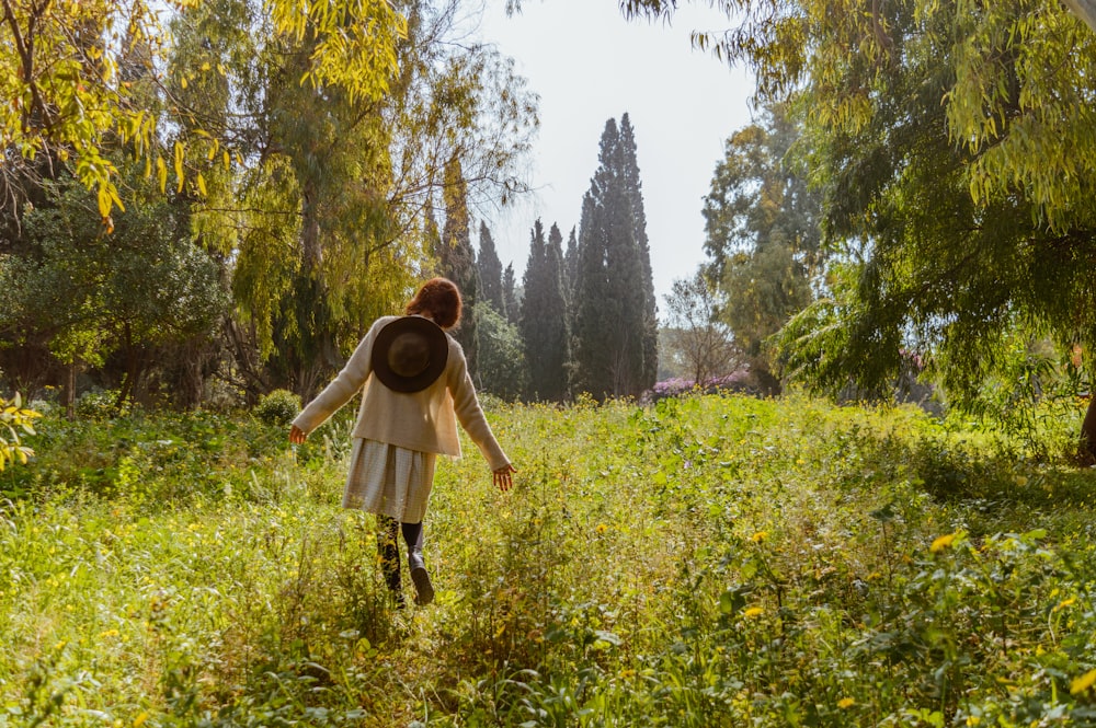 woman in brown jacket standing on green grass field during daytime