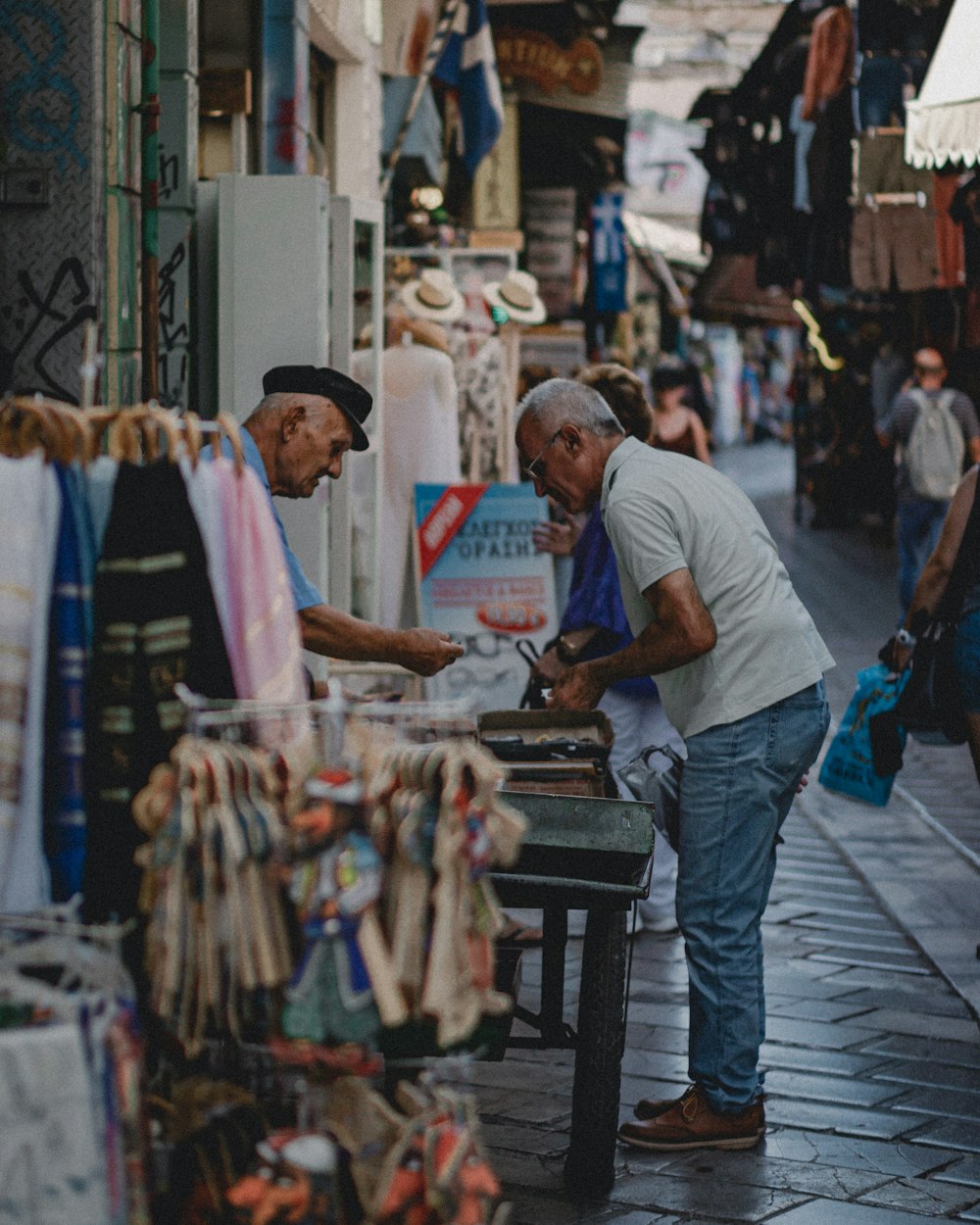 man in white crew neck t-shirt and blue denim jeans standing in front of store