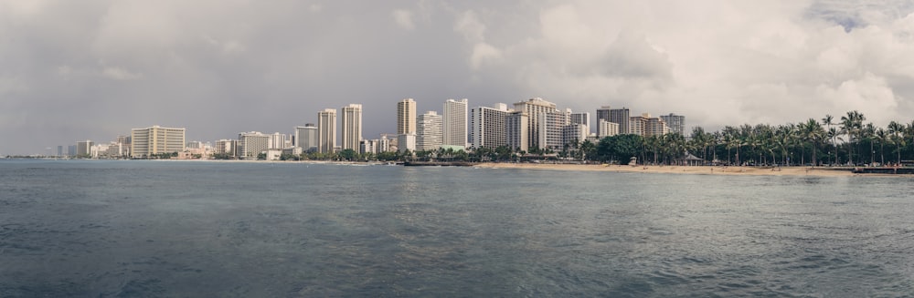 city skyline across body of water under cloudy sky during daytime