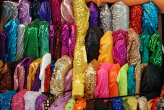 Shiny textiles in bright colors folded and displayed.