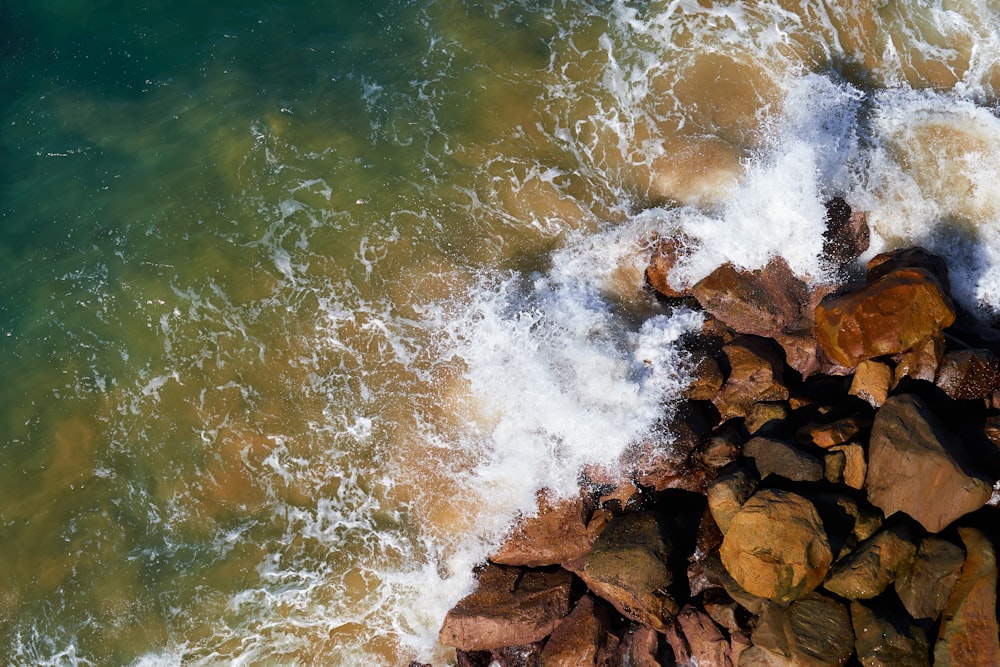 vagues d’eau frappant les roches brunes