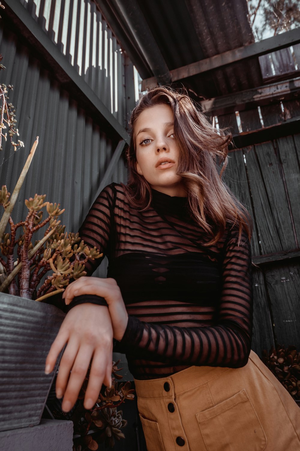 woman in black and brown striped long sleeve shirt sitting on black chair