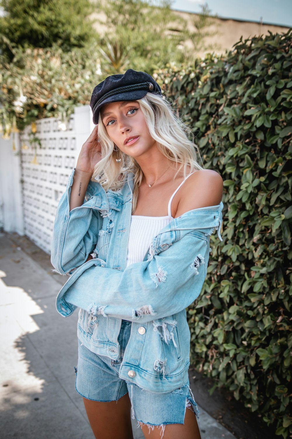 woman in blue denim jacket standing near green plants during daytime