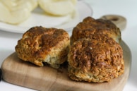 Freshly baked scones arranged on a rustic wooden board.