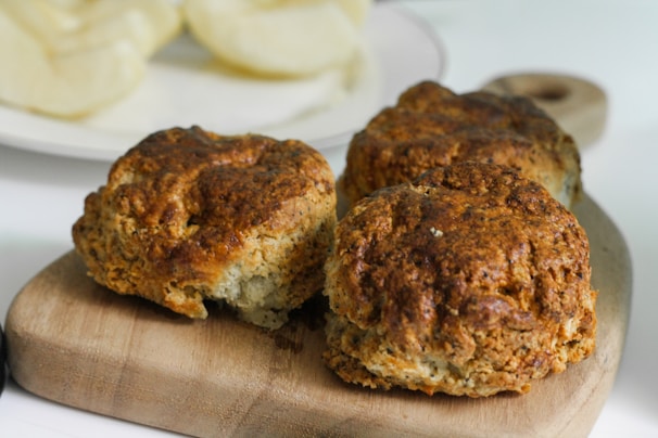 A rustic wooden board displaying spicy gingerbread scones dusted with powdered sugar.