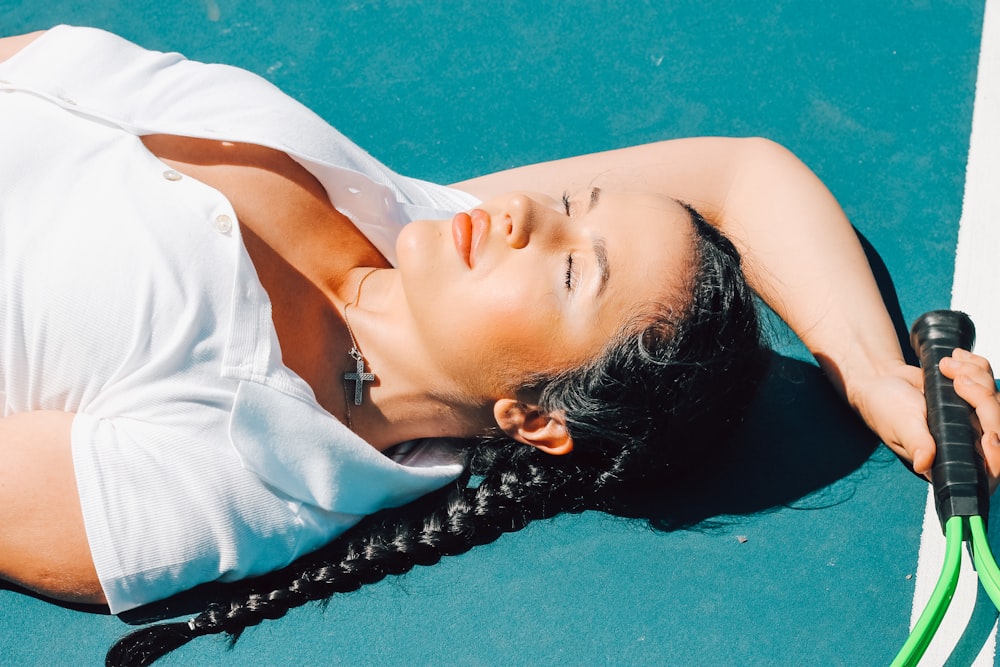 woman in white shirt lying on blue water