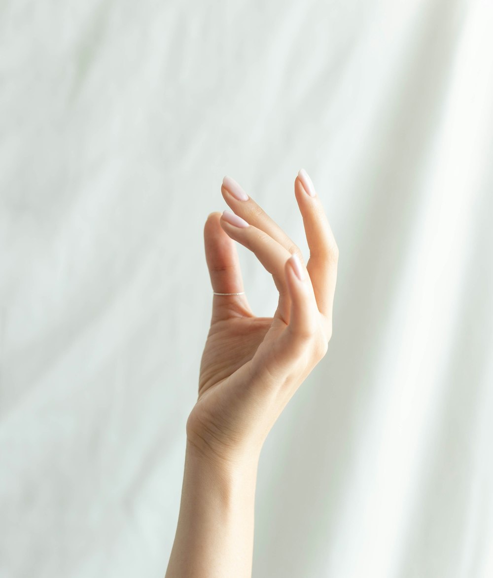 persons left hand on white textile