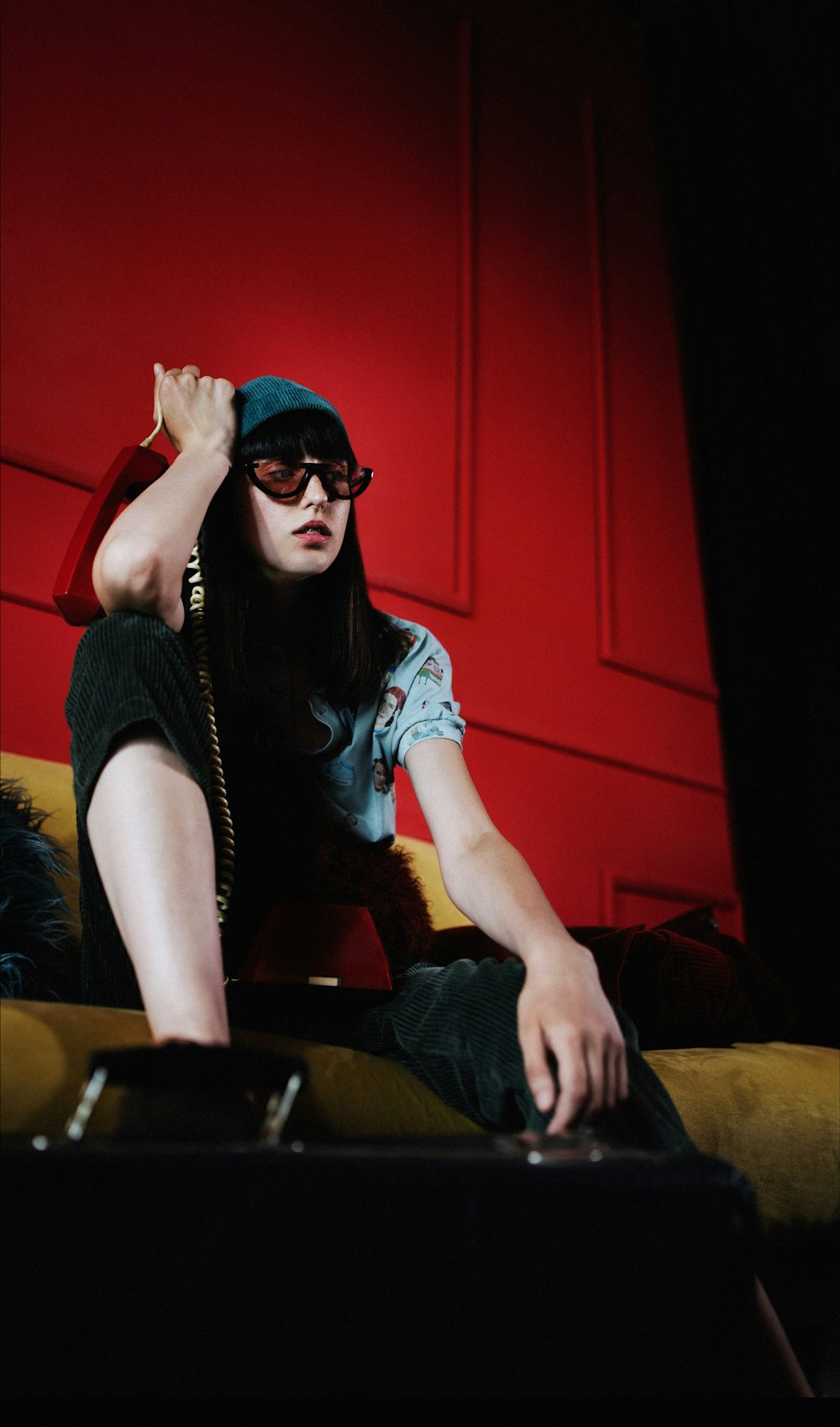 man in black sunglasses and blue denim jeans sitting on brown sofa