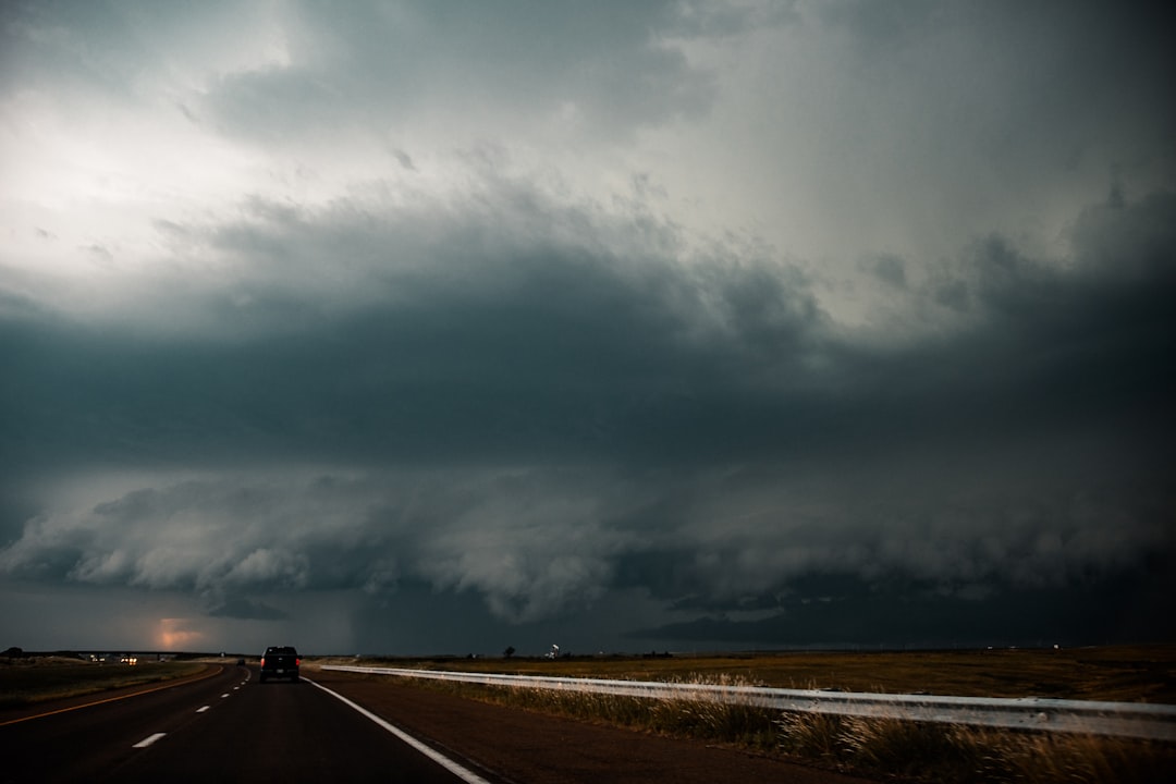 black asphalt road under gray clouds